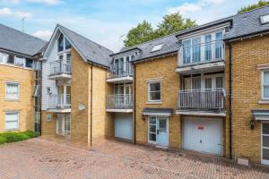 a row of brick apartment buildings with garages at 5-bedroom Haven, Perfect For Business And Leisure in Canterbury