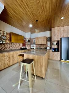 a kitchen with wooden cabinets and a bar with a stool at Kebagusan Park Residence in Jakarta