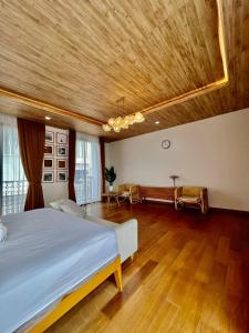 a bedroom with a large bed and a wooden ceiling at Kebagusan Park Residence in Jakarta