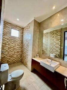 a bathroom with a sink and a toilet and a mirror at Kebagusan Park Residence in Jakarta