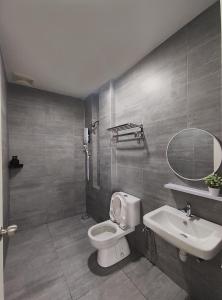 a bathroom with a toilet and a sink and a mirror at Senandika Homestay in Kuching