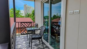 a balcony with a table and chairs on a balcony at The 99 House in Jomtien Beach