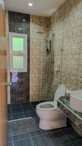 a bathroom with a toilet and a sink and a shower at The 99 House in Jomtien Beach