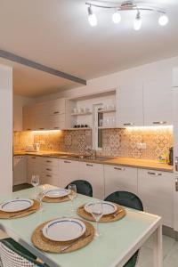eine Küche mit einem Tisch mit Tellern und Weingläsern in der Unterkunft Fancy Modern APT Sliema - w/ 2BR in Sliema