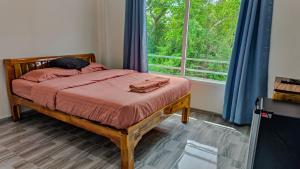 a bedroom with a bed with a large window at 99 House in Jomtien Beach