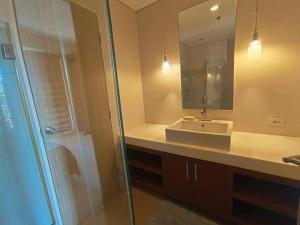 a bathroom with a sink and a shower with a mirror at Luxurious Family Room Pico de Loro in Nasugbu