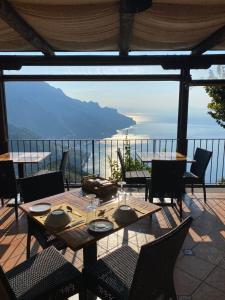 a patio with tables and chairs and a view of the ocean at Da Salvatore B&B in Ravello