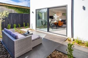 an internal view of a garden with a couch and a patio at Sunsoaked & Stylish 3 Bed, 1.5 Bath Home w Garage in Christchurch