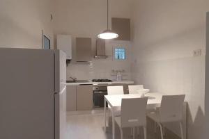 a kitchen with a table and chairs and a refrigerator at Casa Maergilù in Pescara