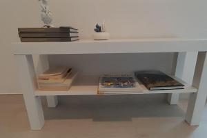 un tavolo bianco con libri su una mensola di Casa Maergilù a Pescara