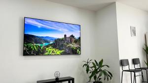 a tv hanging on a white wall in a living room at Relax House Mohelnice in Mohelnice