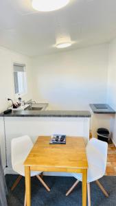 a kitchen with a wooden table and two chairs at 18th Avenue Thermal Motel in Tauranga +73 photos