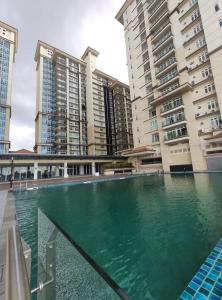 een zwembad voor enkele hoge gebouwen bij Senandika Homestay in Kuching