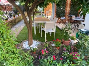 una mesa y sillas bajo un árbol en un jardín en Dimora Leone, en Diamante