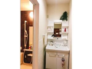 a small bathroom with a sink and a mirror at Guest House SAKURA - Vacation STAY 57751v in Sakura