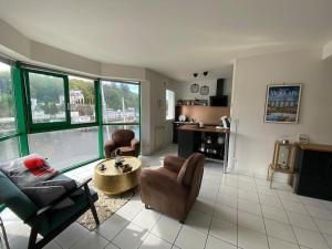 ein Wohnzimmer mit einer Couch und Stühlen und einem Tisch in der Unterkunft Voiles sur Morlaix: vue port, 4 personnes, parking in Morlaix + 25 Fotos