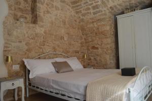 a bedroom with a bed and a stone wall at Geometric Donna Giulia in Casamassima