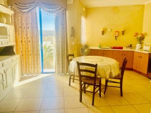 cocina con mesa, sillas y ventana en Ix Xaluppa J6 Apartment, en Għajnsielem