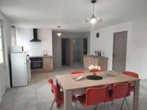 Thonnance-lès-Joinville的住宿－Jolie maison rénovée avec espace vert，厨房以及带桌子和红色椅子的用餐室。