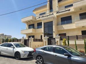 two cars parked in front of a building at Perfect view garden in Amman