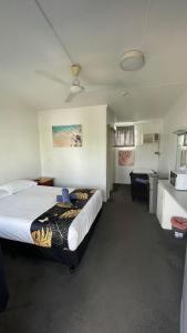 a hotel room with a bed and a kitchen at Cairns City Motel in Cairns