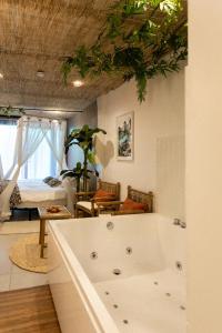 a white bath tub in a room with a bedroom at Bali Serenity Balnéo et lit rond in Lagnieu