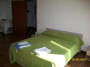 1 dormitorio con 1 cama verde y 2 toallas en Sweet Home 2, en Montopoli in Sabina