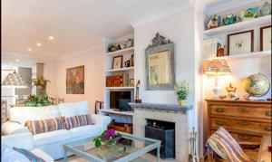 Apartamento Urbanización Benamara في إِستيبونا: غرفة معيشة مع أريكة بيضاء ومدفأة