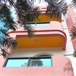 a pink and orange building with palm trees at Guang's Tribe Homestay in Magong