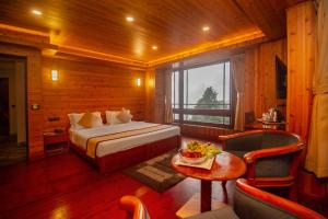 a bedroom with a bed and a table in a room at NRS Norling Retreat in Darjeeling