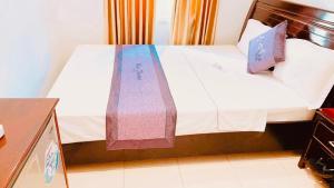 Hue thuong hotel في هوى: سرير مع بطانيات ووسائد ملونة عليه
