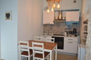 kuchnia z drewnianym stołem i białymi szafkami w obiekcie Geometric Donna Giulia w mieście Casamassima