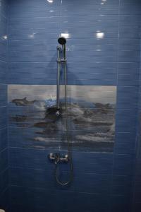 W łazience znajduje się prysznic ze ścianą wyłożoną niebieskimi kafelkami. w obiekcie Apartment Airport Sofia w mieście Sofia