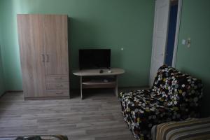 a living room with a couch and a table with a television at Apartment Airport Sofia in Sofia