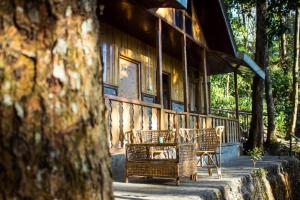 - une terrasse couverte avec des chaises en osier dans l'établissement Vamoose Weekend Resort, à Rhenok