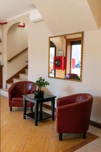 a living room with two chairs and a table and a mirror at Rex Hotel Residence in Genoa