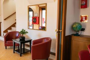 a waiting room with red chairs and a mirror at Rex Hotel Residence in Genoa