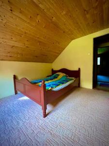 a bed in a room with a wooden ceiling at Riksberg Chalet in Harghita Mountains in Vărşag +14 photos