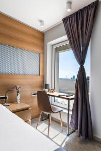 um quarto com uma secretária e uma janela em Prince Rooftop em Belgrado