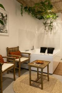 a living room with chairs and a table and a sink at Bali Serenity Balnéo et lit rond in Lagnieu