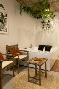 sala de estar con sillas, mesa y lavamanos en Bali Serenity Balnéo et lit rond, en Lagnieu