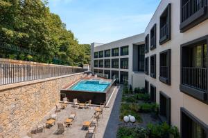 - une vue extérieure sur un bâtiment avec une piscine et des chaises dans l'établissement INVENTIST Hotel Sports Academy Istanbul, à Istanbul