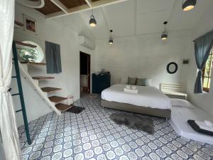 een slaapkamer met een bed en een trap erin bij The Little Clay House (Huahin) in Ban Thap Tai (1)