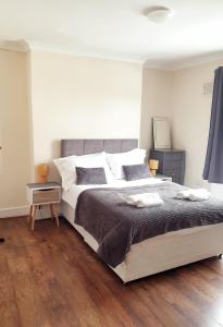 1 dormitorio con 1 cama grande y suelo de madera en 2 Bedroom Apartment 2 Min Walk to Station - longer stays available, en Gravesend