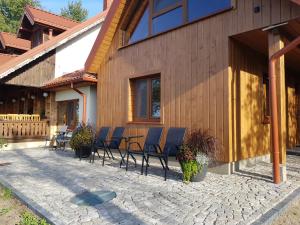 a group of chairs sitting outside of a house at Dolina Biebrzy - Chata Flisaka in Wroceń +20 photos