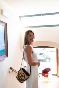 a woman in a white dress holding a purse at Rex Hotel Residence in Genoa
