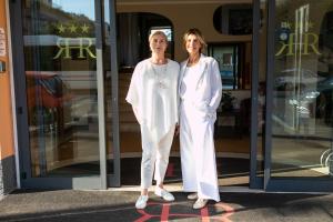 two women standing in front of a store at Rex Hotel Residence in Genoa
