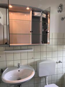 La salle de bains est pourvue d'un lavabo et d'un miroir. dans l'établissement Gäste, Handwerker Zimmer - 2 Betten, à Rosenfeld