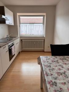 eine Küche mit einem Tisch, einem Waschbecken und einem Fenster in der Unterkunft Gäste, Handwerker Zimmer - 2 Betten in Rosenfeld
