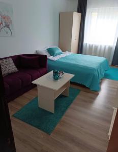 a bedroom with a bed and a table and a couch at Happy M&S 2 in Šabac